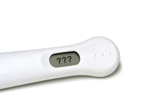 Close-up of a pregnancy test showing question marks on the screen, symbolising uncertainty and the emotional challenges of infertility