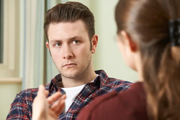 Young man listening intently to a therapist during a counselling session, reflecting a safe space to share and process emotions.